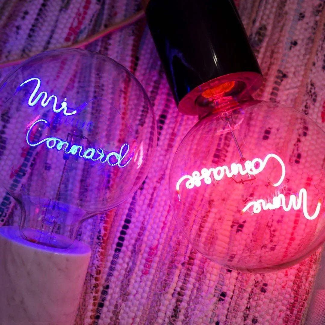 Deux ampoules LED design à message lumineux coloré sur tapis tressé