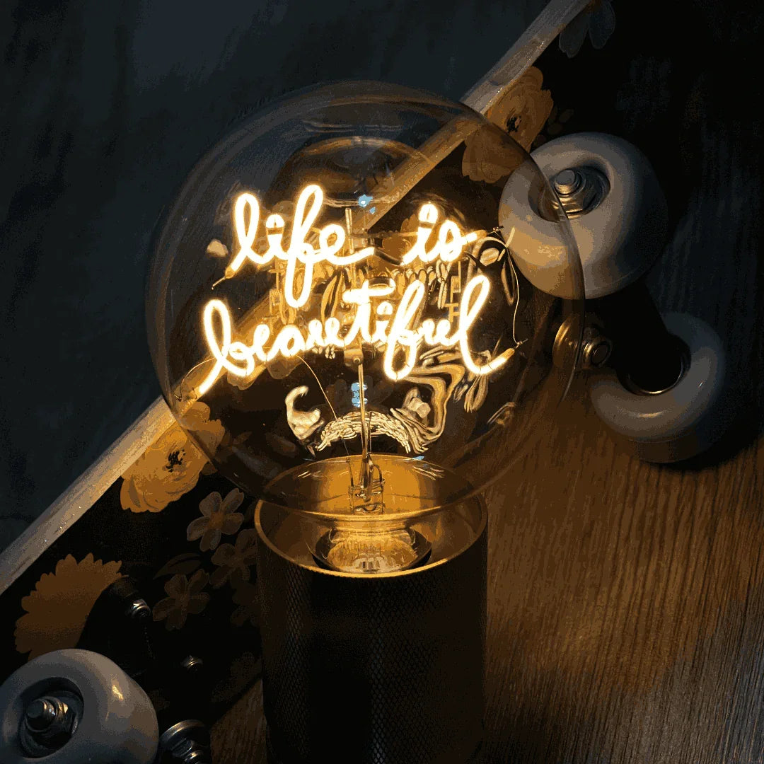 Ampoule LED design avec message lumineux «life is beautiful», socle métal, ambiance moderne.