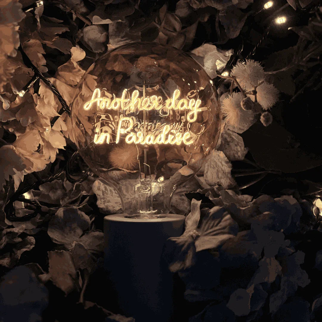 Ampoule LED à message lumineux "Another day in paradise" sur socle, décor floral
