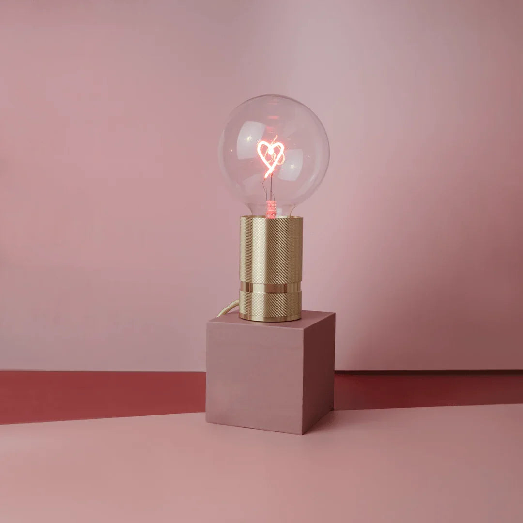 Lampe design avec ampoule LED cœur et socle doré, décor sobre rose, style moderne